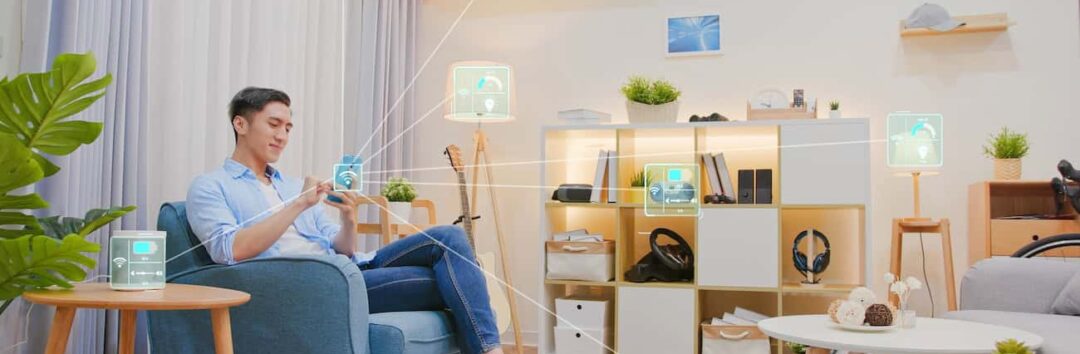asian man sitting on sofa and using smart home control app on mobile phone with augmented reality view of IOT connected objects in apartment